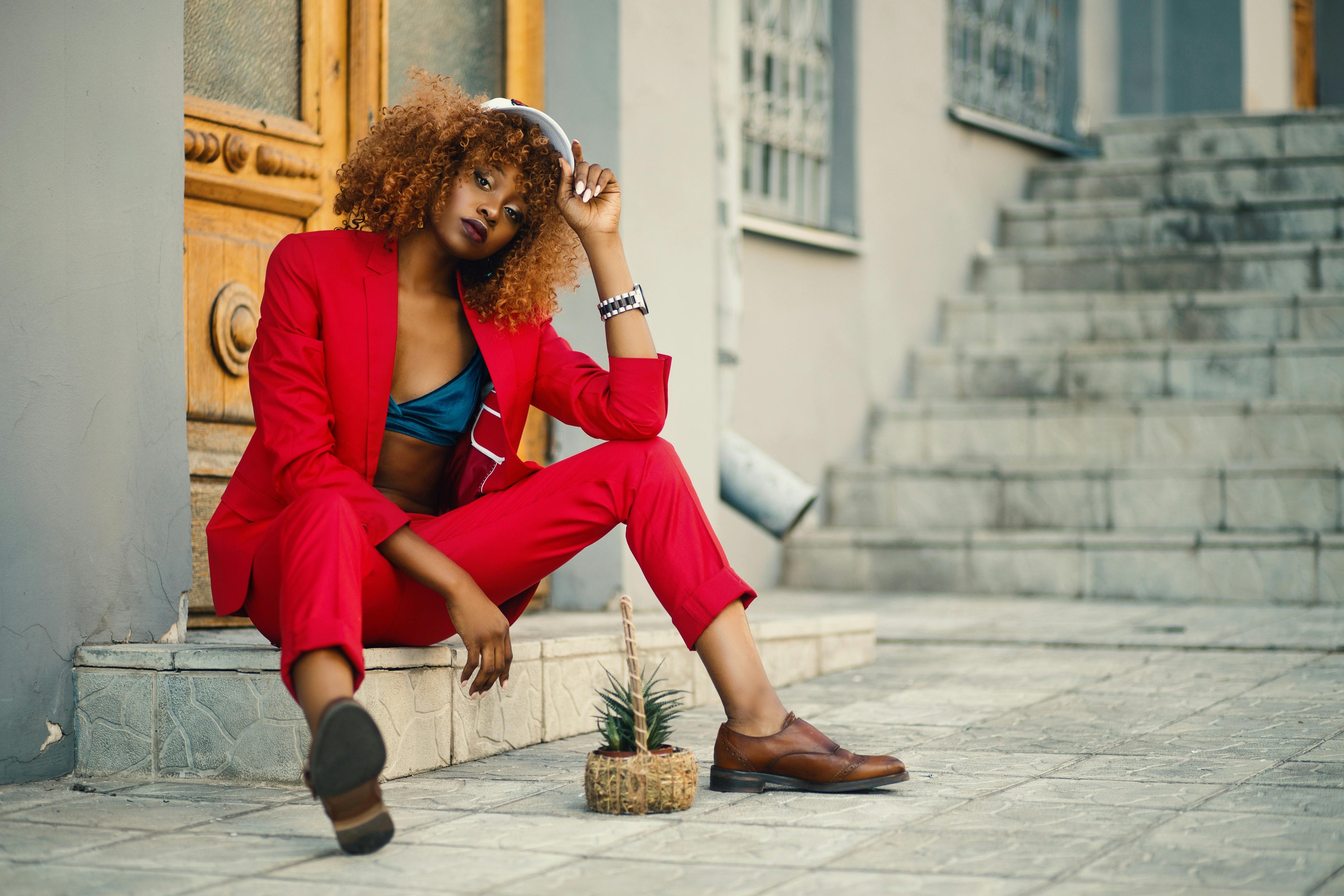 Woman in a red outfit sitting on steps outdoors